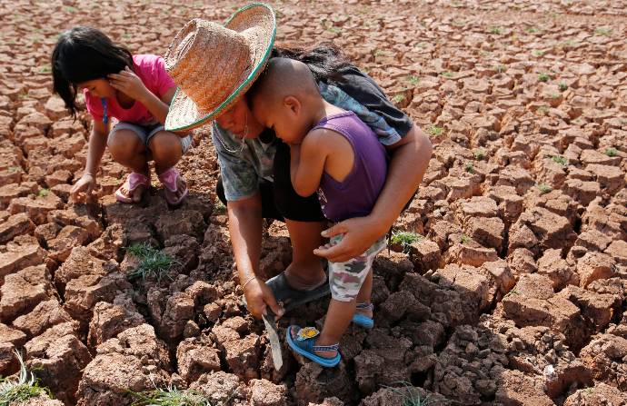 Imagen de archivo de una madre con sus hijos buscando alimento en un campo afectado por la sequía. Foto: EFE