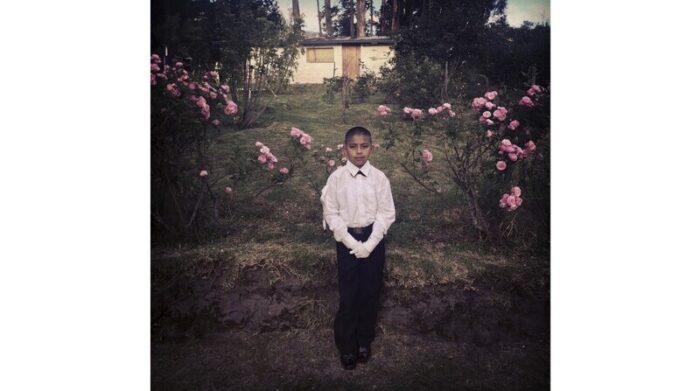 Bryan Andrés Achance, de 11 años, frente a su casa antes de su primera comunión, en Rumihuaico. Foto: Iván Kashinsky