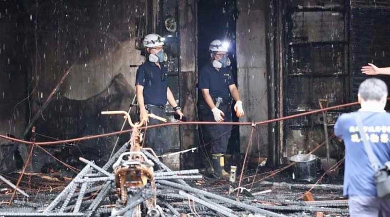 Autoridades locales investigan el sitio después de un incendio en un edificio comercial y residencial en la ciudad de Kaohsiung, en el sur de Taiwán, el 14 de octubre de 2021. Foto: EFE
