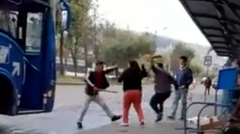 Las imágenes muestran a dos hombres, uno con un palo y otro con un machete, golpeándose frente a un bus que se encuentra detenido en Quito. Foto Captura
