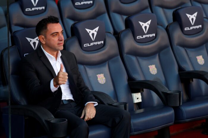 El nuevo entrenador del FC Barcelona, Xavi Hernández, posa en el banquillo del Camp Nou tras finalizar el acto de presentación como entrenador blaugrana. EFE/Alejandro García