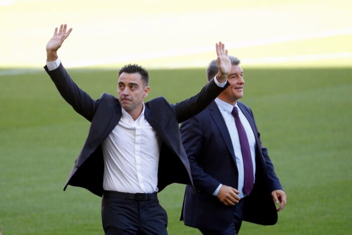 El nuevo entrenador del FC Barcelona, Xavi Hernández, junto al presidente del club, Joan Laporta (d), saluda a los aficionados que se han citado en las gradas del Camp Nou durante el acto de presentación como entrenador blaugrana. EFE/Alejandro García