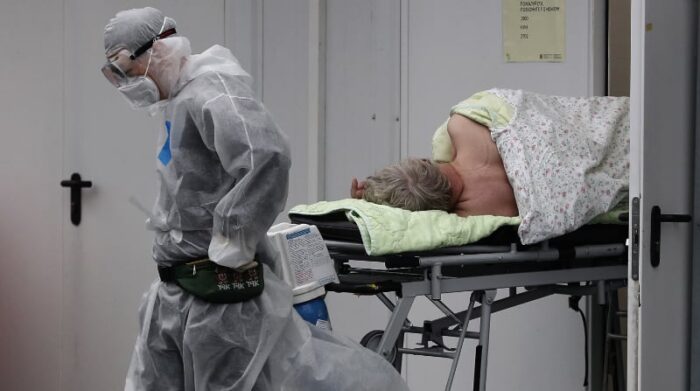 Un trabajador sanitario acompaña a un paciente de covid-19 al complejo hospitalario del asentamiento de Kommunarka en Moscú, Rusia, este 5 de noviembre de 2021. Rusia ha registrado número de casos máximos desde marzo del 2020, en el inicio de la pandemia. Foto: EFE