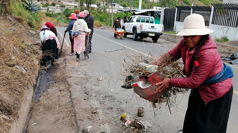 Un grupo de mujeres trabaja en la limpieza y mantenimiento de la vía asfaltada hacia Cuatro Esquinas en Santa Rosa. Foto: Modesto Moreta / EL COMERCIO