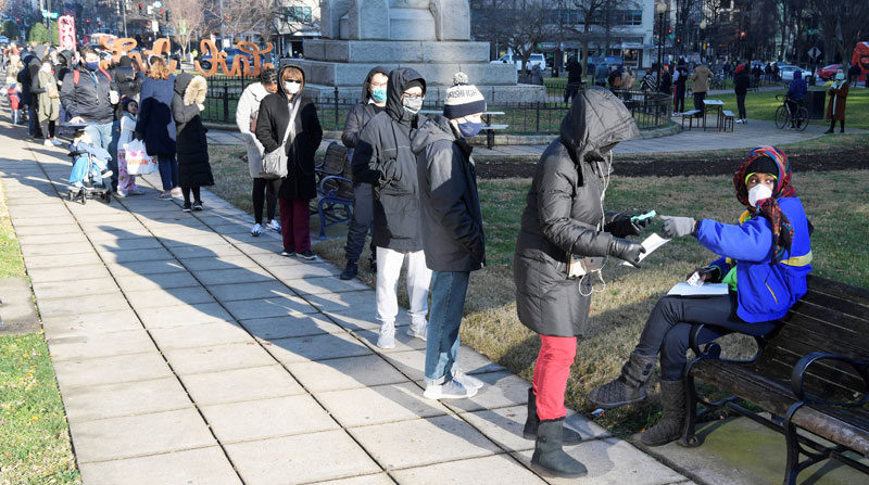 Personas esperan en una fila para hacerse pruebas gratis de covid-19, debido al incremento de la variante Ómicron en el parque Farragut Square en Washington, EE.UU. Foto: EFE