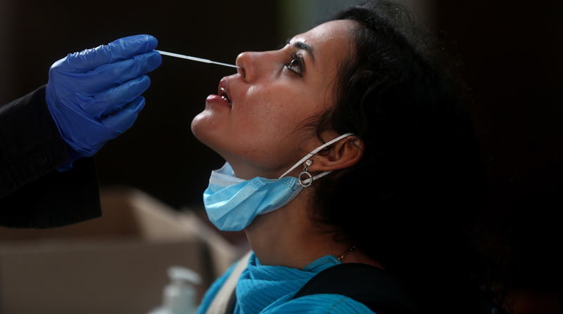 Una mujer se somete a una prueba de frotis nasal para detectar covid-19 en la estación de tren de Bangalore, India, el 31 de diciembre de 2021. Foto: EFE