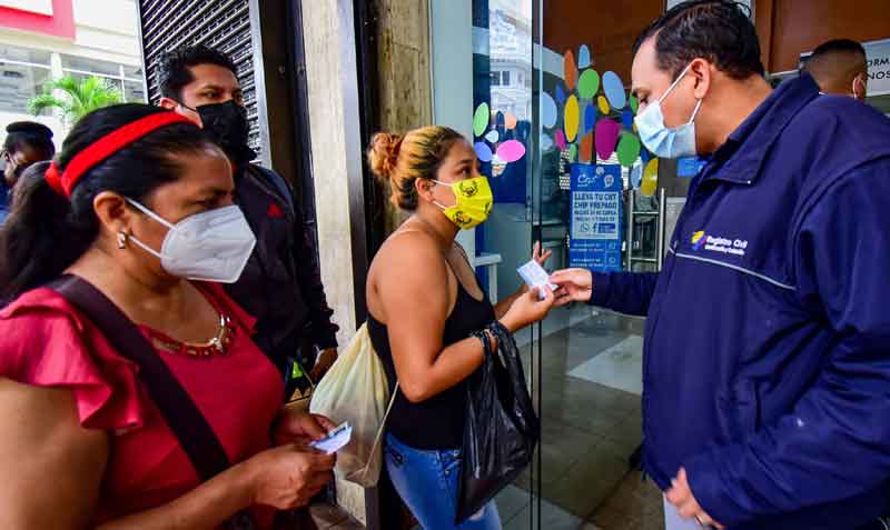 En las instituciones públicas exigen el carné o certificado de vacunación. En el Registro Civil de Guayaquil, usuarios muestran sus documentos de vacunación para ingresar. Foto: Enrique Pesantes / EL COMERCIO