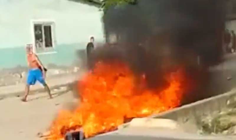 En videos virales se observa a un joven en pantaloneta azul rociar con rabia el combustible a los cuerpos inmóviles en el piso, en plena calle. Luego los cuerpos aparecen prendidos en llamas.