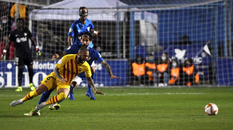 El centrocampista del Linares Fran Carnicer (detrás) comete falta sobre Dani Alves, defensa brasileño del Barcelona, en la Copa del Rey. Foto: EFE