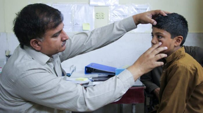 Un paciente siendo atendido en el centro especializado en el tratamiento de la leishmaniasis cutánea en Peshawar, Pakistán. El paciente es Mohammad Asif, de 11 años, quien tiene una lesión en uno de sus ojos. Foto: Nasir Ghafoor / MSF