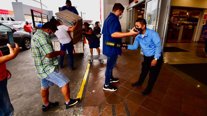 Guardias de seguridad chequean a clientes del Riocentro Los Ceibos, en Guayaquil, con detectores de metales antes de ingresar al centro comercial. Foto: Enrique Pesantes/ EL COMERCIO