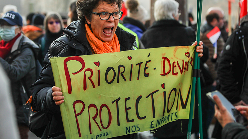 Una mujer sostiene un cartel que dice "La prioridad debe ser la protección de nuestros niños" durante una manifestación encabezada por el partido de derecha Les Patriotes contra el certificado covid digital de la UE, cerca de la Torre Eiffel en París, Francia, el 15 de enero de 2022. Foto: EFE