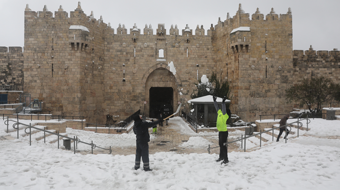 Los palestinos juegan en la nieve después de una tormenta de nieve cerca de la puerta de Damasco en la ciudad vieja de Jerusalén, el 27 de enero de 2022. Foto: EFE