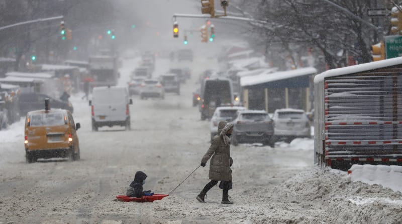 Una mujer tira de un niño en un trineo de nieve a través de la Novena Avenida en Nueva York, Nueva York, EE.UU. este 29 de enero de 2022. La gran tormenta está golpeando una parte sustancial de la costa este de los Estados Unidos, interrumpiendo los viajes y se pronostica que algunas áreas recibirán hasta 2 pies (61 centímetros) de nieve. Foto: EFE