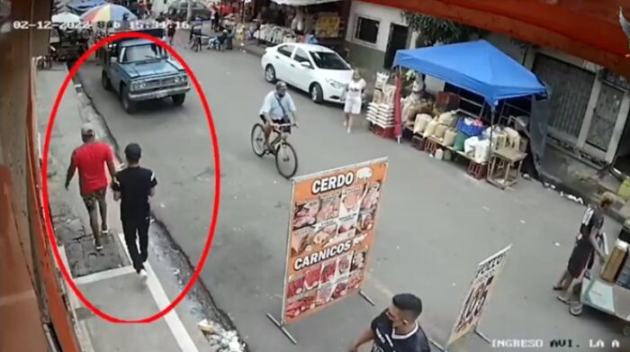 Hombres caminan luego de haber cometido un robo a mano armada en un local comercial ubicado en el sector Cristo del Consuelo, en Guayaquil. Foto: Captura de pantalla