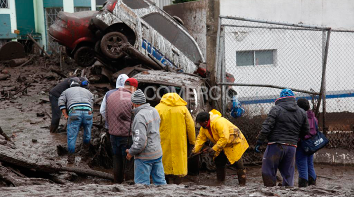 El cuerpo de un niño quedó atrapado entre los vehículos de la zona también estancados por el lodo del aluvión. Foto: Patricio Terán / EL COMERCIO
