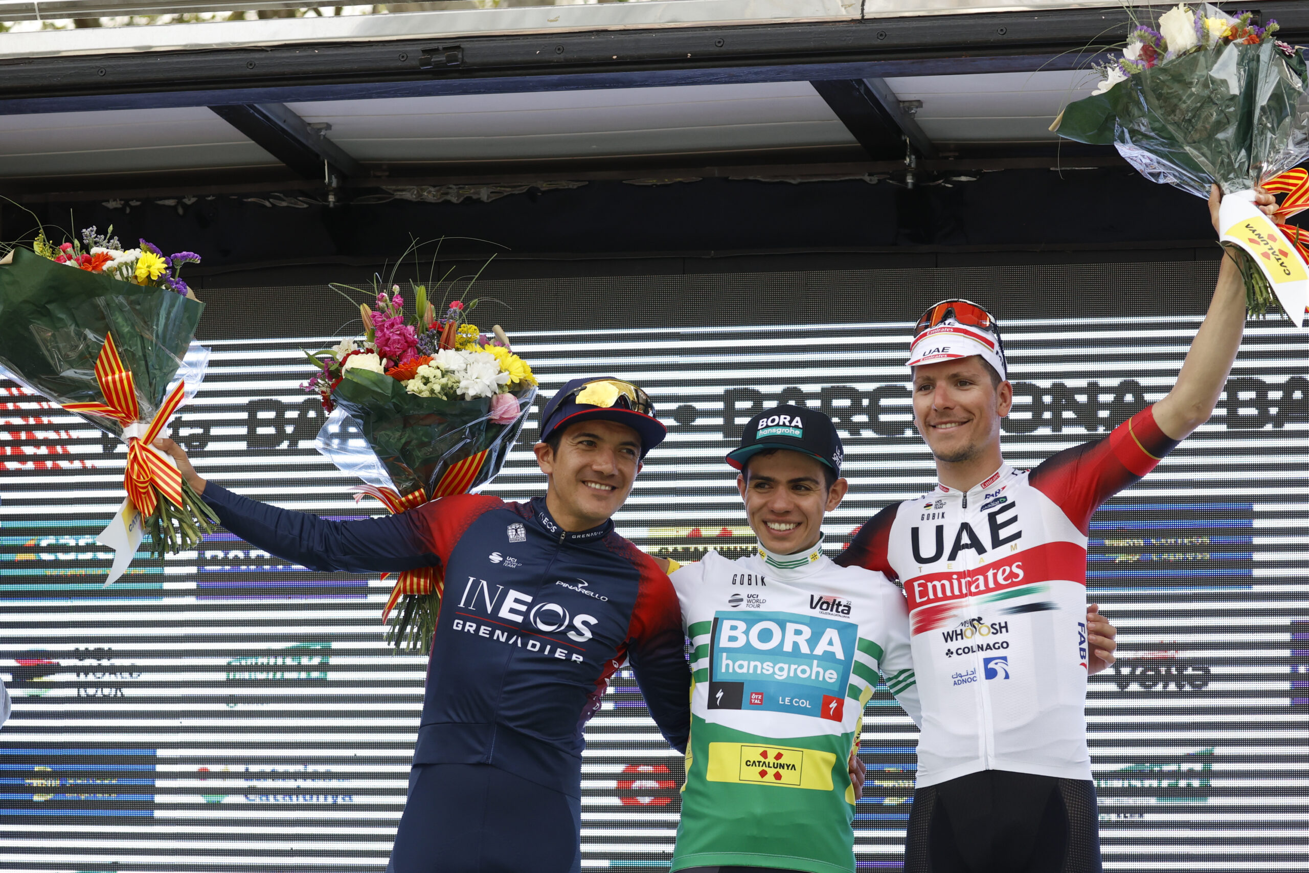 El ciclista colombiano Sergio Higuita (BORA-Transgohe) (c), primer clasificado, el ecuatoriano Richard Carapaz, segundo clasificado (i), del Ineos Grenadiers y el portugués Joao Almeida (d), tercer clasificado, del UAE Team Emirates, en el podio tras la séptima y última etapa de la en la Volta a Catalunya, este domingo en Barcelona. EFE/ Toni Albir