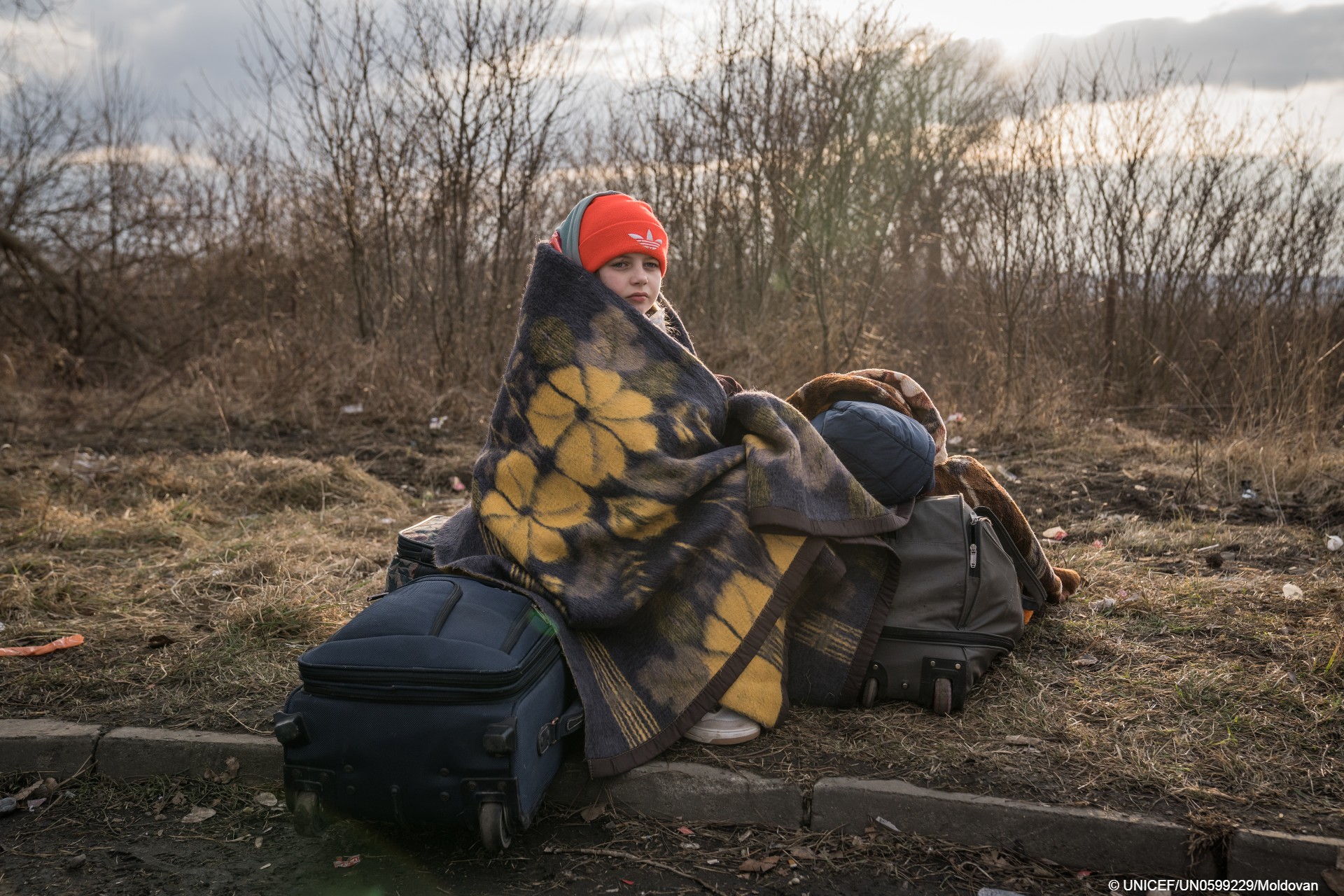 Una niña huye de Ucrania por el conflicto armado.