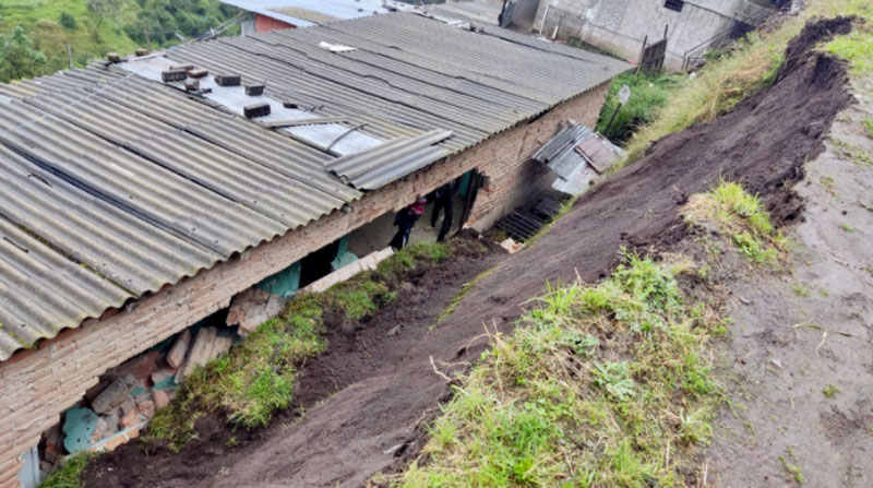 El material del derrumbe destruyó la pared de un dormitorio y la sala de una vivienda en Atucucho, norte de Quito. Foto: Bomberos Quito