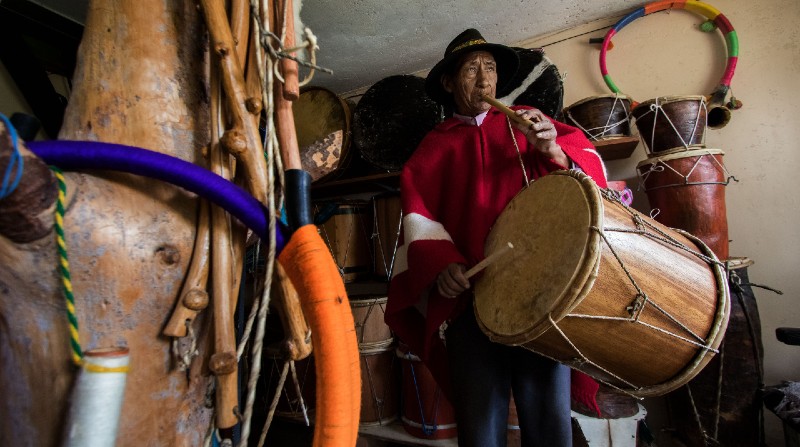 Con su poncho rojo y sombrero negro, Rosalino toca el pingullo y el tambor. En su taller se exhiben instrumentos hechos por él mismo. También mazorcas de maíz que cuelgan de la pared, como adornos. Foto: Carlos Noriega / El Comercio
