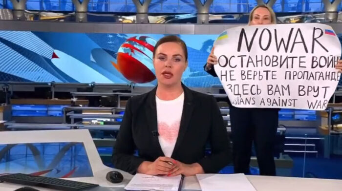 La activista se colocó detrás de la presentadora y expuso un cartel en el que rechazaba la guerra entre Rusia y Ucrania. Foto: Captura de pantalla