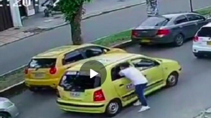 Ladrón mete la mitad de su cuerpo por la ventana de un taxi para robar a pasajero. Foto: Captura