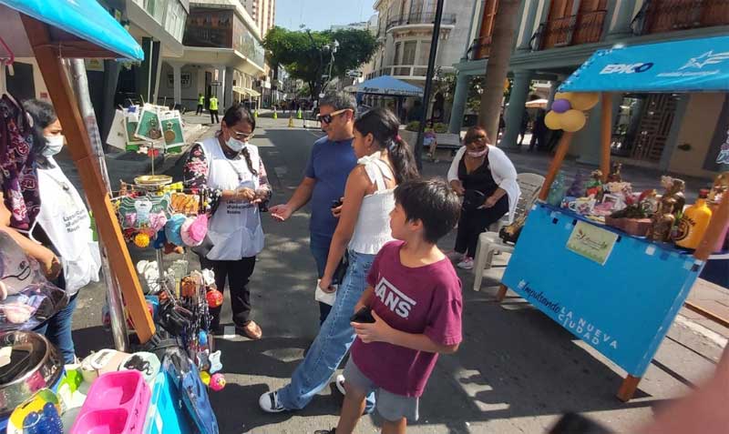 Cineli Rosales recibió la visita de Víctor Quesada en su stand. El hombre le compró uno de los productos que ella ofrece. Foto: Juan Carlos Holguín / EL COMERCIO