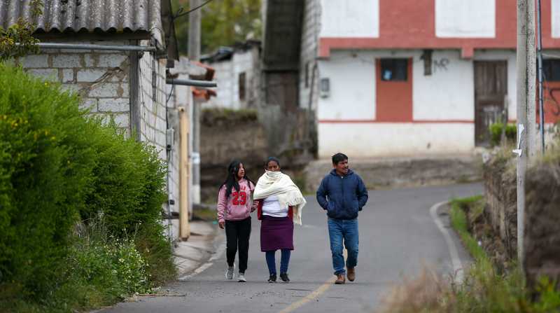 Un grupo de personas camina por una calle vacía, el 9 de abril de 2022, en Ambatillo. Foto: EFE/ José Jácome