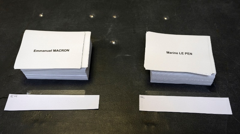 Las boletas de Emmanuel Macron y Marine Le Pen sobre una mesa en la segunda vuelta de las elecciones presidenciales francesas, en un colegio electoral en Burdeos, Francia, este 24 de abril de 2022. Foto: EFE