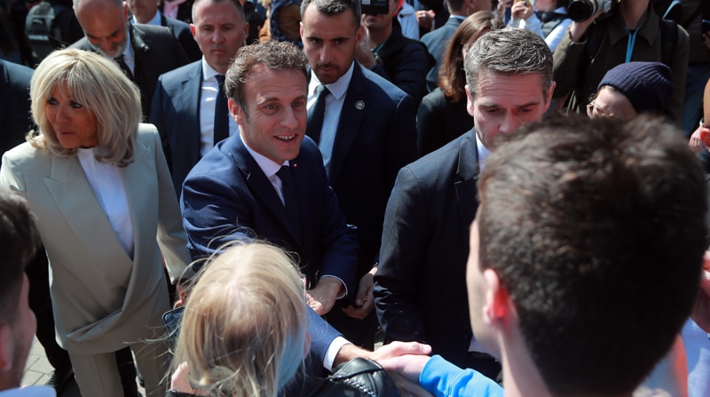 El presiente francés y candidato a la reelección, Emmanuel Macron (c), y su mujer Brigitte (i) saludan a varias personas antes de acudir a un colegio electoral en la segunda vuelta de las elecciones presidenciales, en Le Touquet, Francia, este 24 de abril de 2022. Foto: EFE