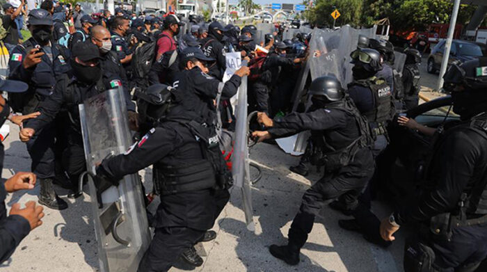 Policías auxiliares que protestaban por mejoras en su salario se enfrentan a miembros de la policía antimotines. Foto: EFE