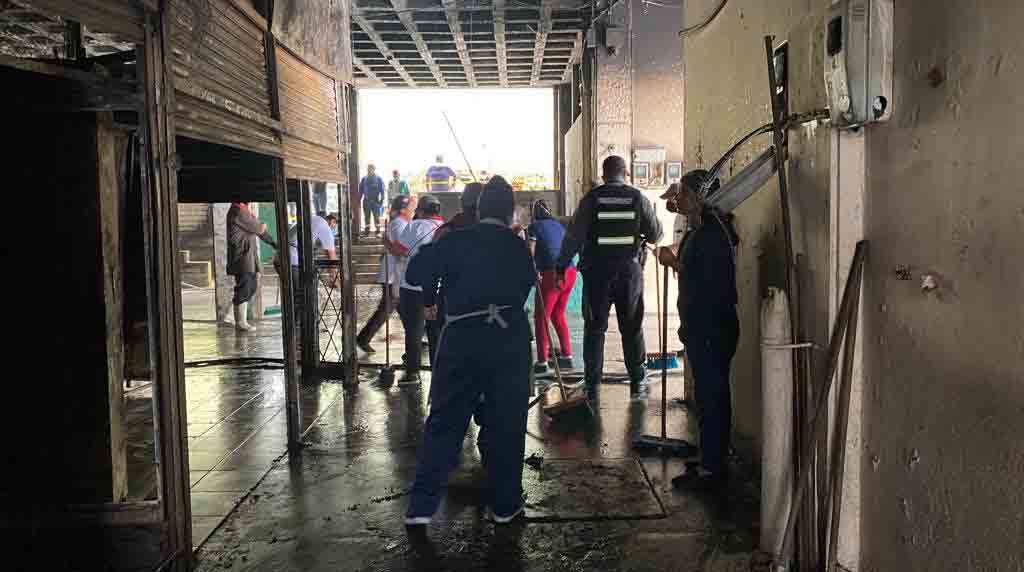 Un grupo de comerciantes del mercado Santa Clara, norte de Quito, realizan trabajos de limpieza en la parte afectada por el incendio del sábado. Foto: Patricio Terán / EL COMERCIO.