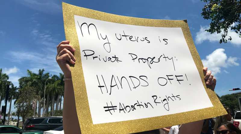 Una mujer sostiene una pancarta que dice "Mi útero es propiedad privada, ¡No lo toques!" durante un acto celebrado a las afueras de la llamada Torre de la Libertad en Miami, Florida. Foto: EFE/Ana Mengotti