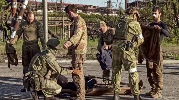 Imagen tomada de un video facilitado por el ministerio de Defesa ruso que muestra a varios soldados rusos cacheando a militares ucranianos,tras salir de la acería de Azovstal, en Mariúpol. Foto: EFE.