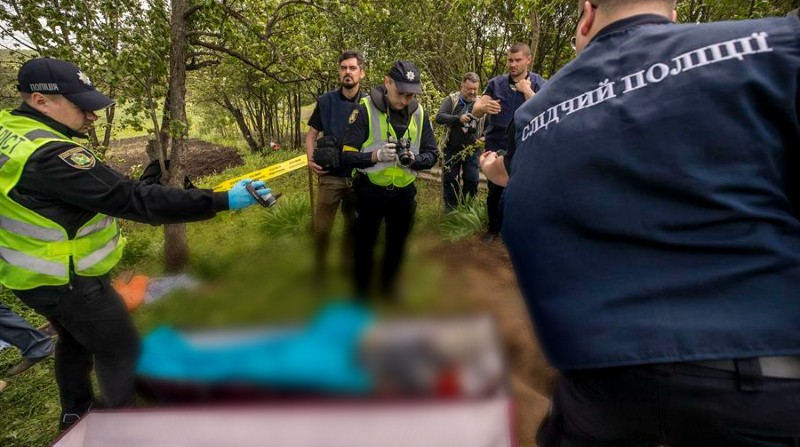 El proceso de exhumación de un ciudadano ucraniano que resultó muerto a causa de los impactos de artillería durante un ataque ruso, en Járkov, el 27 de mayo 2022. Foto: EFE