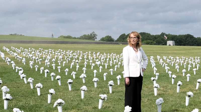 La excongresista demócrata y sobreviviente de un tiroteo, Gabby Giffords, posa en medio de una instalación con unos jarrones de flores blancas que representan al número de víctimas de la violencia con armas, este martes cerca del Monumento a Washington en el National Mall, en Washington (EE.UU.) Foto: EFE/Jorge Dasti