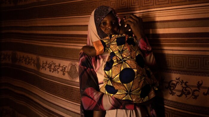 M. está cuidando a los hijos de algunos inmigrantes que viven en el gueto mientras los padres trabajan durante el día en Agadez, Níger. Foto: © Yarin Trotta del Vecchio 