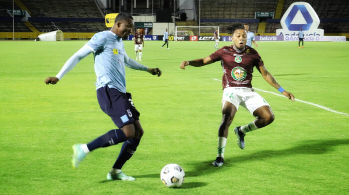 Jugador de la Universidad Católica (derecha) intenta controlar el balón ante la marca de un futbolista de Mushuc Runa. Foto: Twitter @UCatolicaEC.