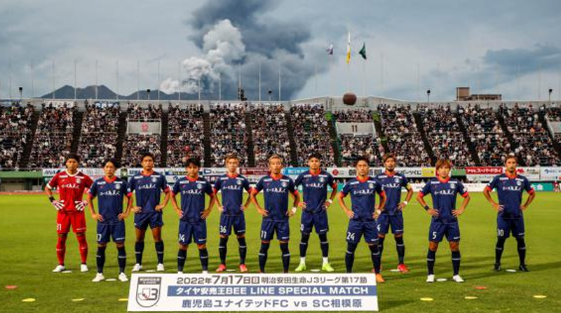 Jugadores del Kagoshima United y detrás el Volcán Sakurajima erupcionando. Foto: Twitter @kagoshimaufc.