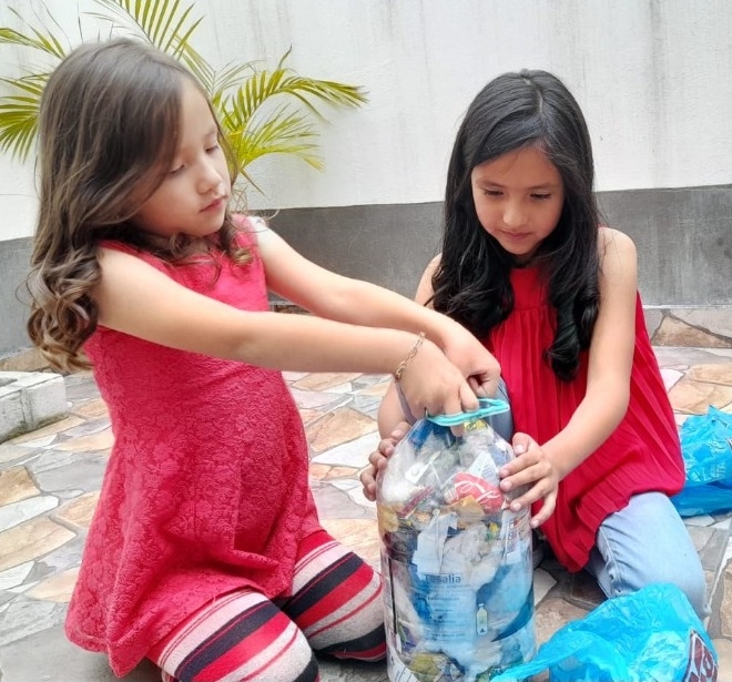 Mhia Valentina y Linda Isabella Lara reciclan las fundas plásticas para darles un nuevo uso. Lo mismo hacen con los cartones. Foto: Cortesía
