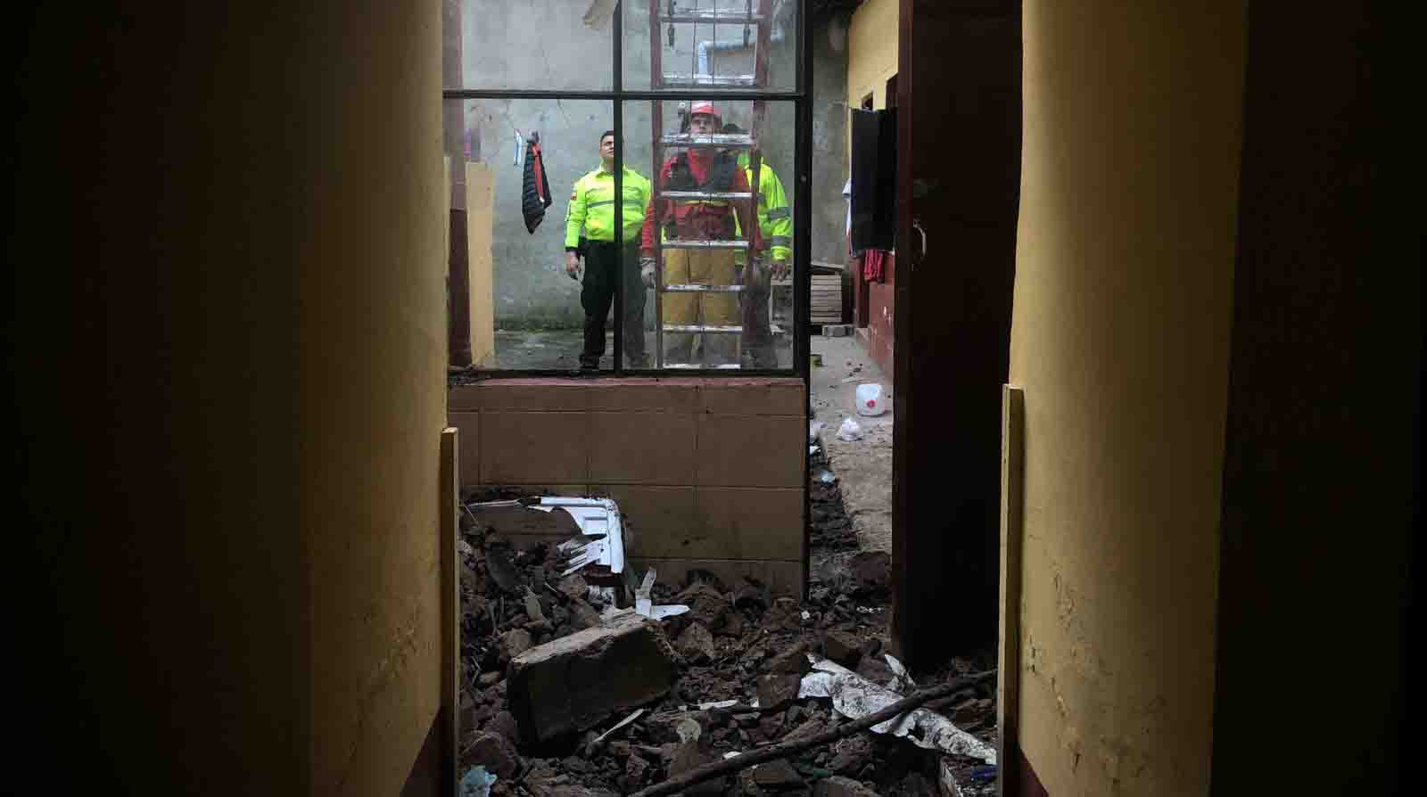 Personal de los Bomberos y de la Policía Nacional dentro de una de las viviendas afectadas por el sismo registrado en Carchi. Foto: Julio Estrella / EL COMERCIO.