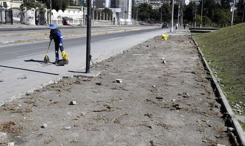 Entre las calles 6 de Diciembre y Tarqui personal de Emaseo limpia los escombros y material que fue utilizado para obstaculizar el paso vehicular. Foto: Diego Pallero / EL COMERCIO