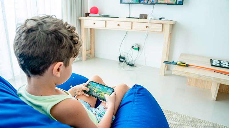 Imagen referencial. Representación gráfica de un niño jugando mientras ve la televisión. Foto: Pixabay