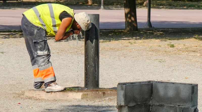 Un trabajador se refresca en una fuente de un parque de Lleida, en Cataluña, España. Allí las temperaturas superan los 41 °C. FOTO: EFE