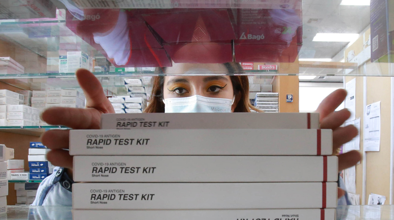 Gissela Romero, dependienta de una cadena de farmacias, organiza los test rápidos de covid-19 en la percha, durante el primer día de venta. Foto: Julio Estrella / EL COMERCIO