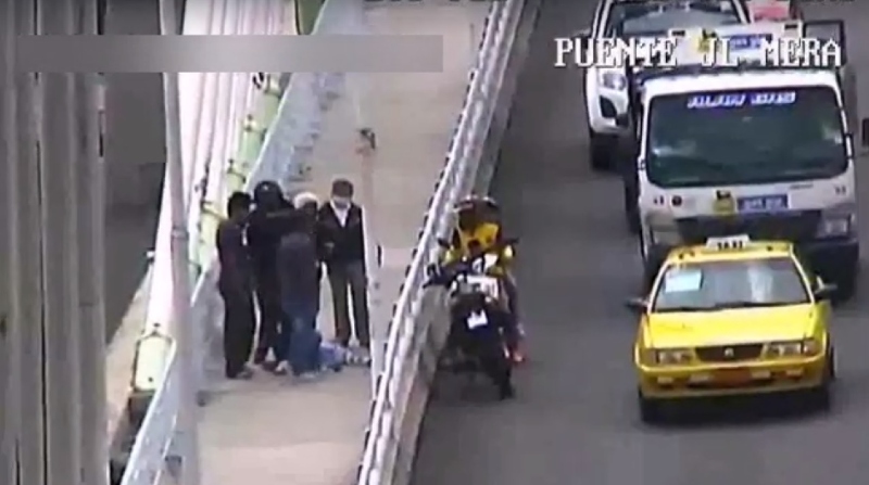 Un transeúnte impidió que un hombre se arroje de un puente en Ambato. Foto: Captura de video ECU 911
