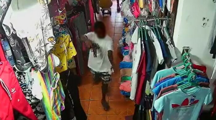 Una cámara de videovigilancia captó a un menor de edad entrar a una tienda con un arma y sustrayendo dispositivos móviles en Esmeraldas. Foto: Captura