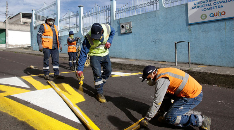Trabajadores municipales colocan y pintan las señales de tránsito en los exteriores de los planteles en Quito, a días del inicio a clases. Foto: Carlos Noriega/ EL COMERCIO