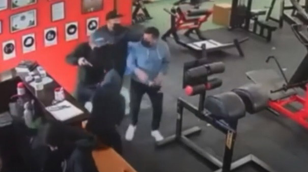 Los hombres armados amenazan a los clientes que ingresan al gimnasio. Foto: Captura de pantalla.
