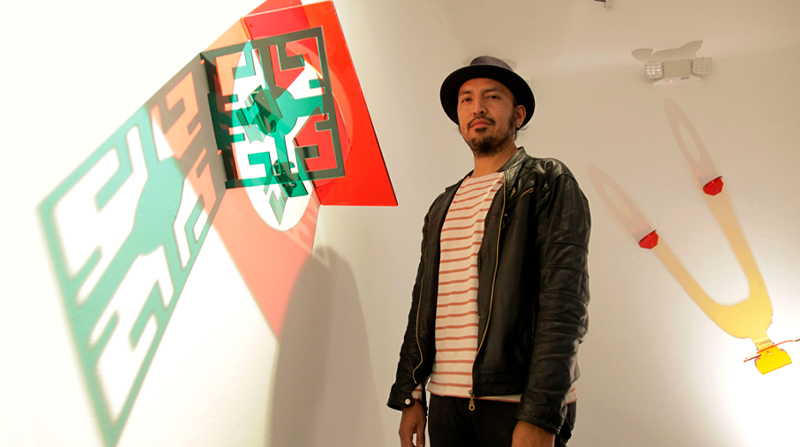 José Luis Macas junto a dos de las piezas lumínicas que se exhiben hasta octubre en la galería N24. Fotos: Patricio Terán /EL COMERCIO